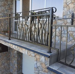 Kované zábradlie s rastlinným vzorom.